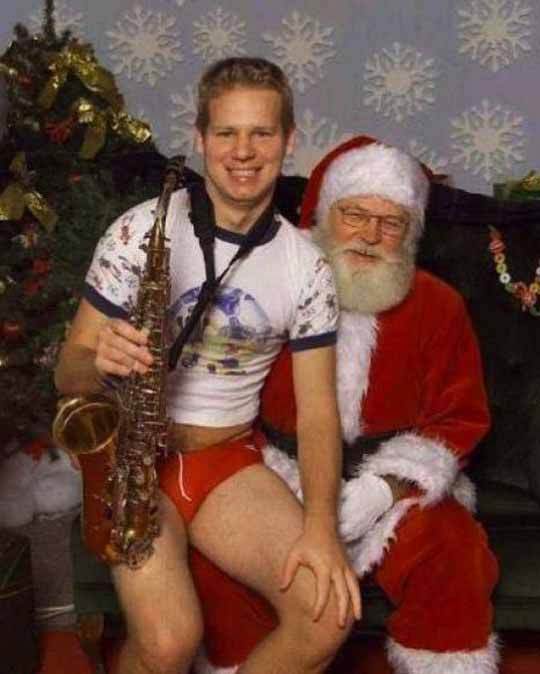 handsome lad with saxophone sits with santa in a friendly encounter - meme