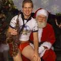 handsome lad with saxophone sits with santa in a friendly encounter
