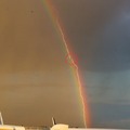 Picture of a lightning striking a plane in front of a rainbow