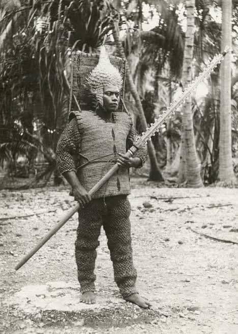Kiribati warrior equipped with a porcupinefish skin helmet, coconut fiber armor, and a shark tooth spear. - meme