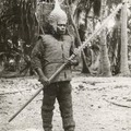 Kiribati warrior equipped with a porcupinefish skin helmet, coconut fiber armor, and a shark tooth spear.