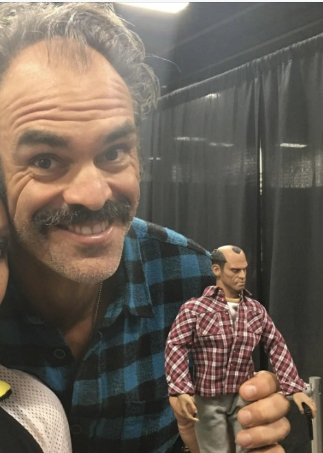 el actor de voz de trevor, con un muñeco de trevor - meme