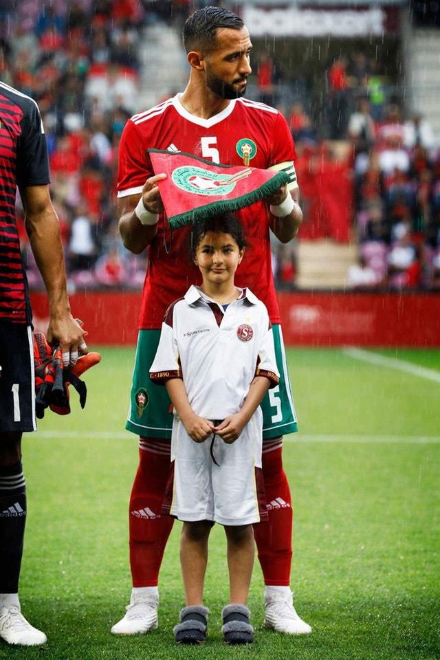 Moroccan soccer player protectinga little girl from the rain - meme